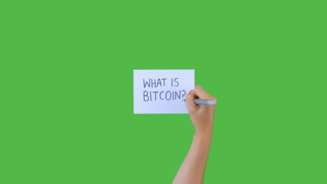 Mujer-Escribiendo-Qué-Es-Bitcoin-En-Papel-Con-Pantalla-Verde